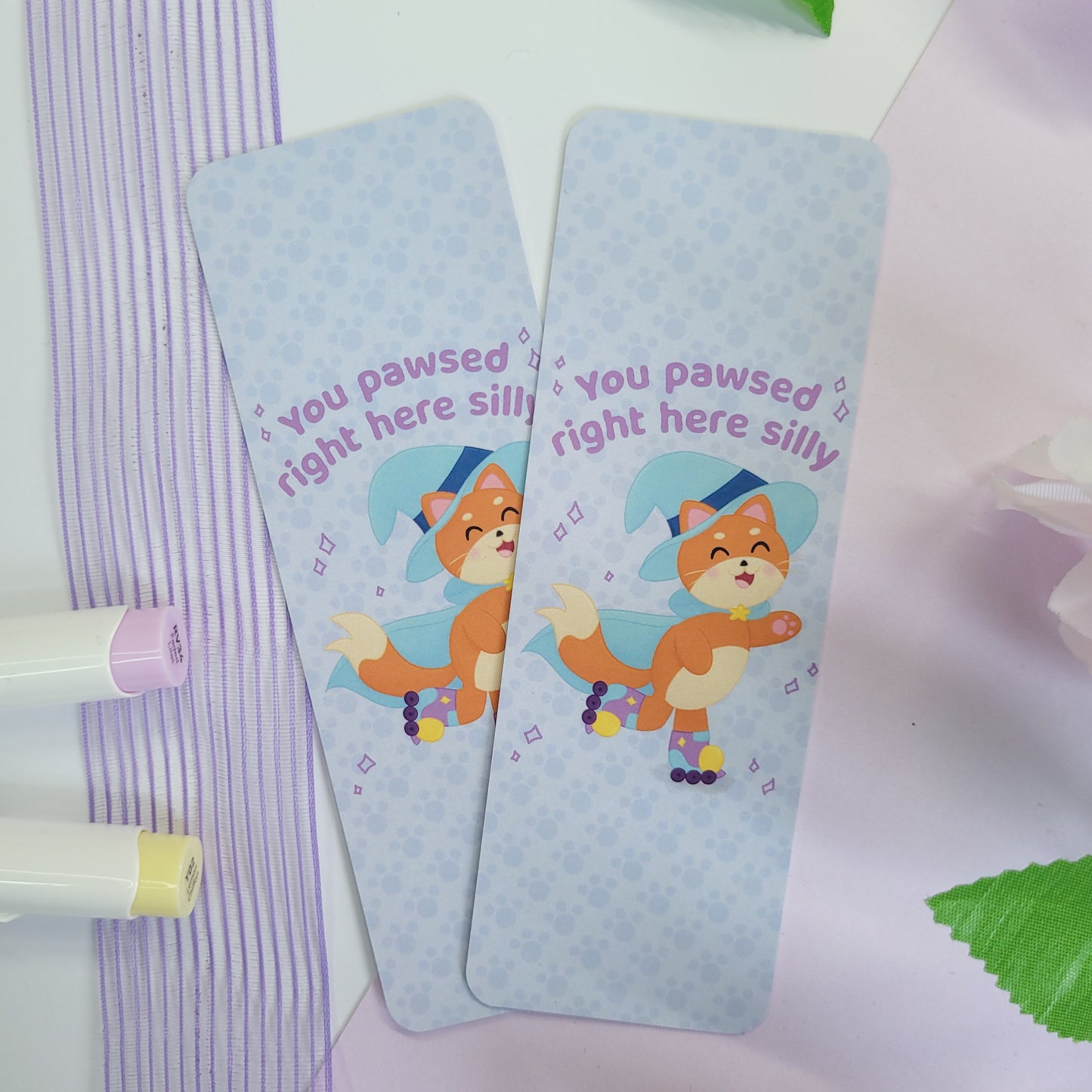 Katrina the kitty witch bookmark with her rollerskating with the text "you pawsed right here silly"