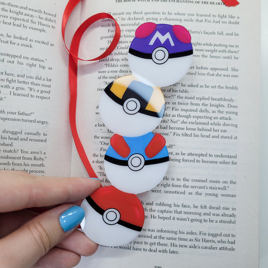 Cute bookmark in the shape of 4 stacked pokeballs shown in use