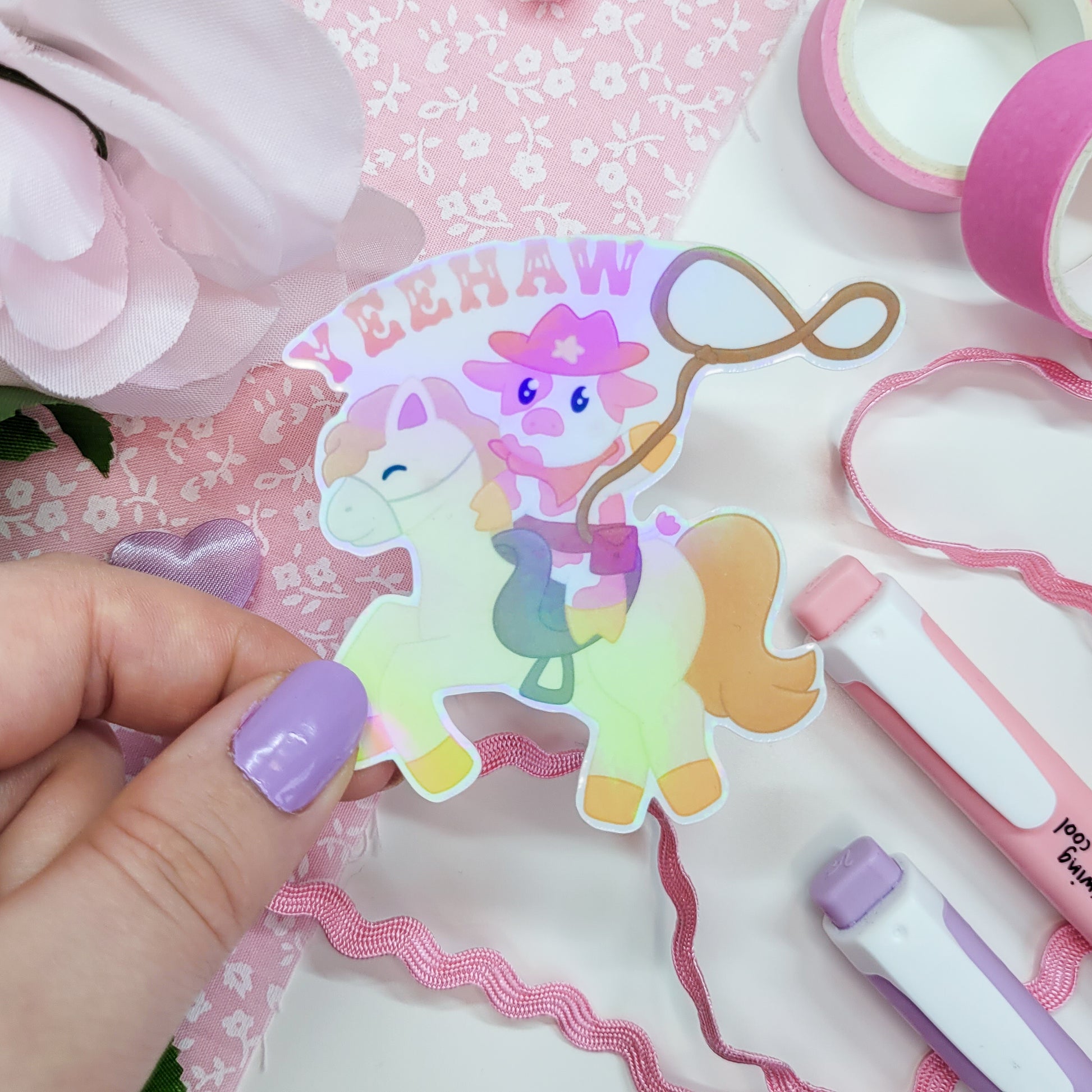 Cute cowboy sticker featuring a cow riding a horse with a lasso saying Yeehaw!