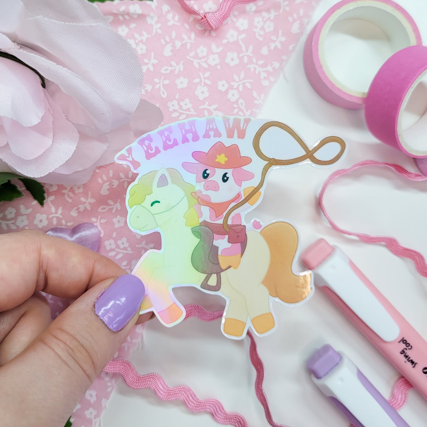 Cute cowboy sticker featuring a cow riding a horse with a lasso saying Yeehaw!