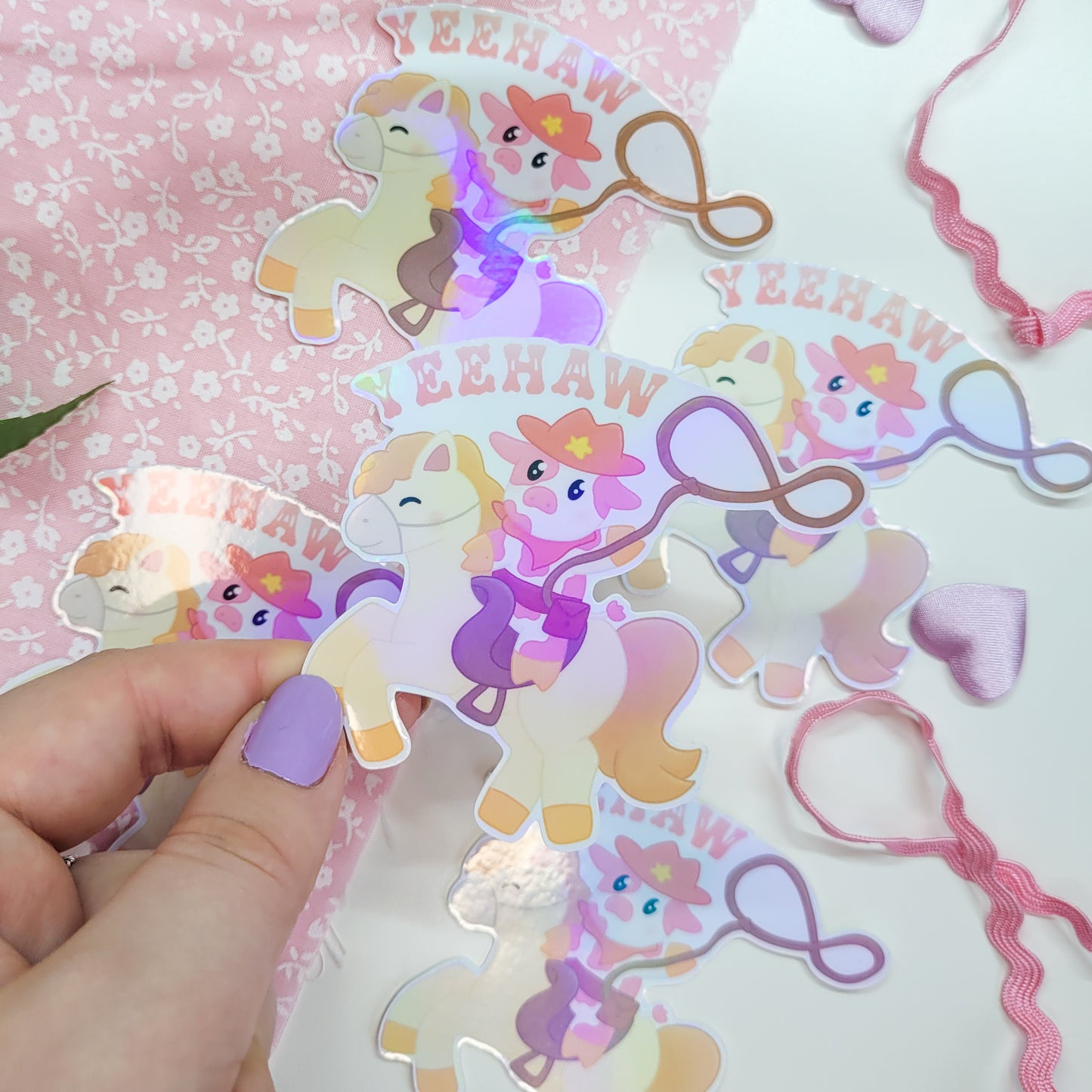 Cute cowboy sticker featuring a cow riding a horse with a lasso saying Yeehaw!