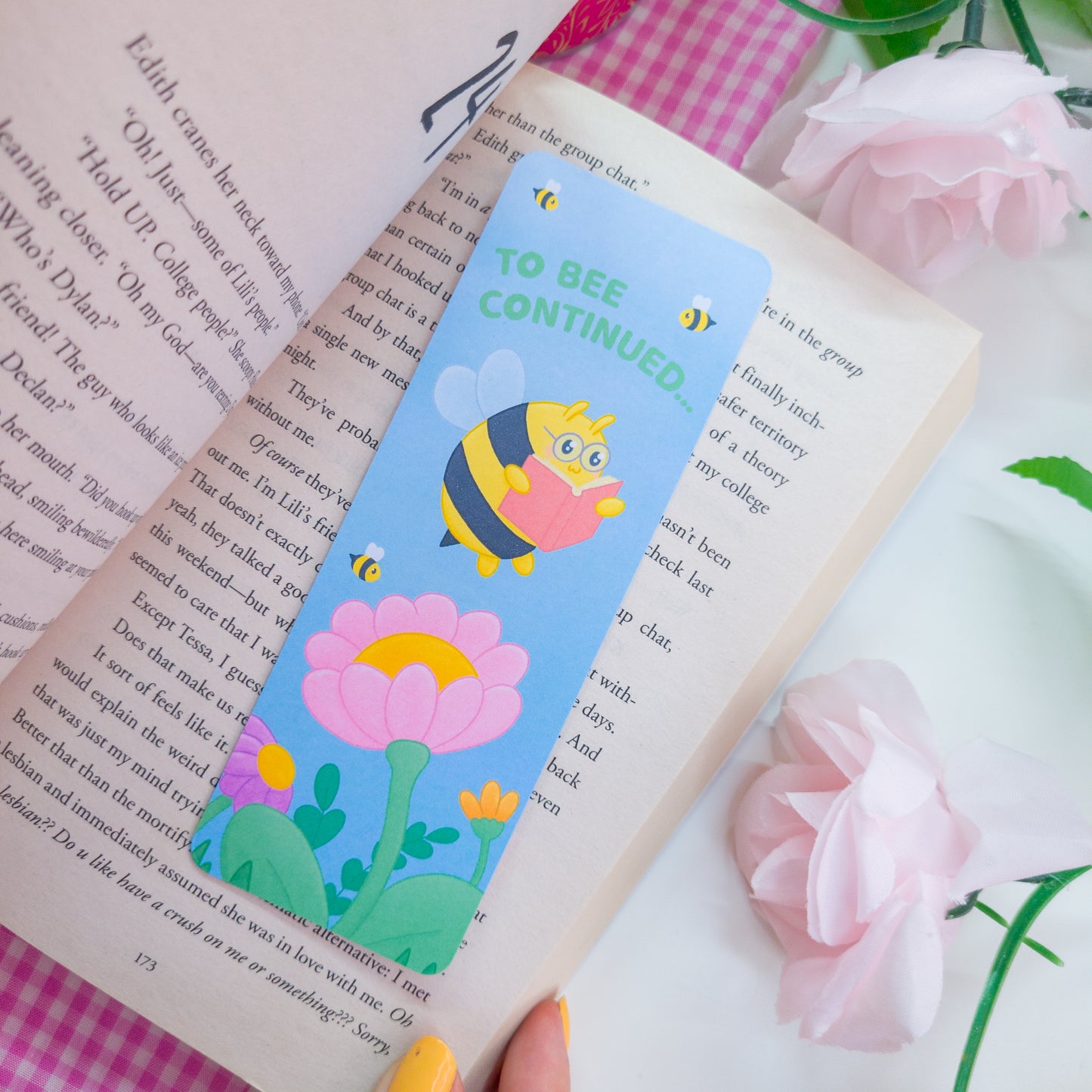 to bee continued bookmark featuring a bee reading among flowers