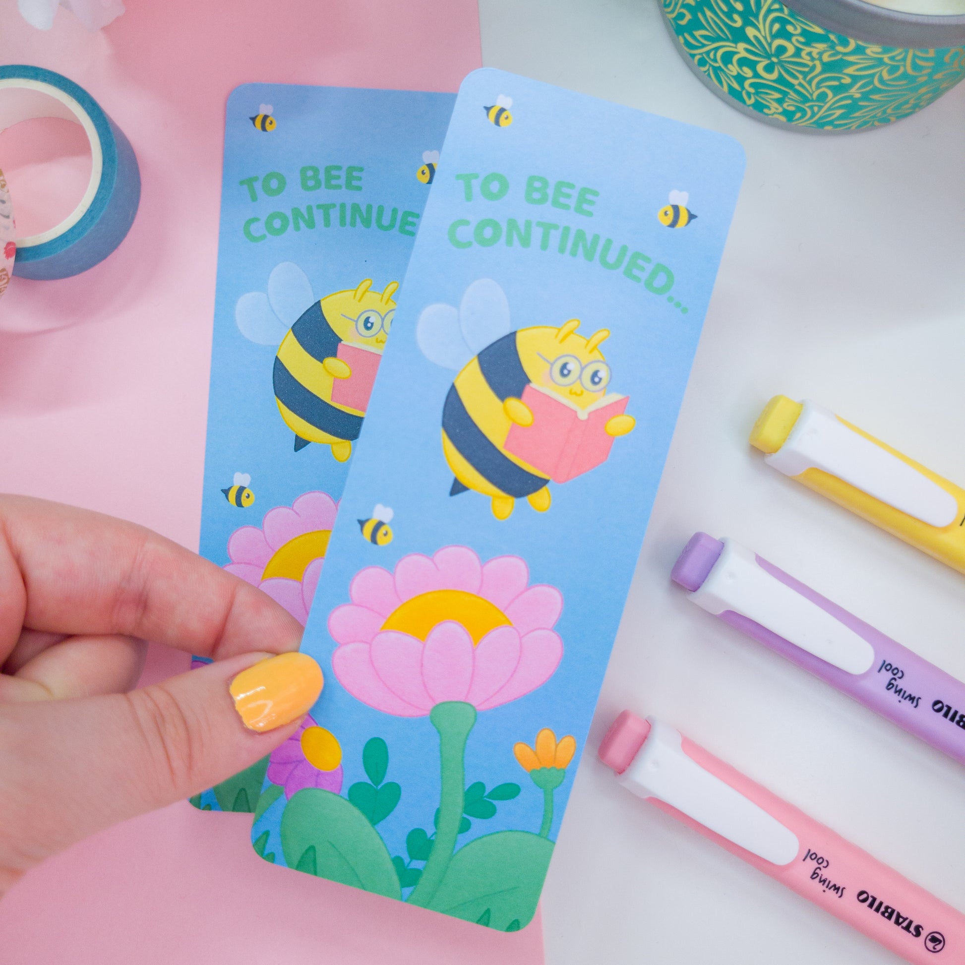 to bee continued bookmark featuring a bee reading among flowers