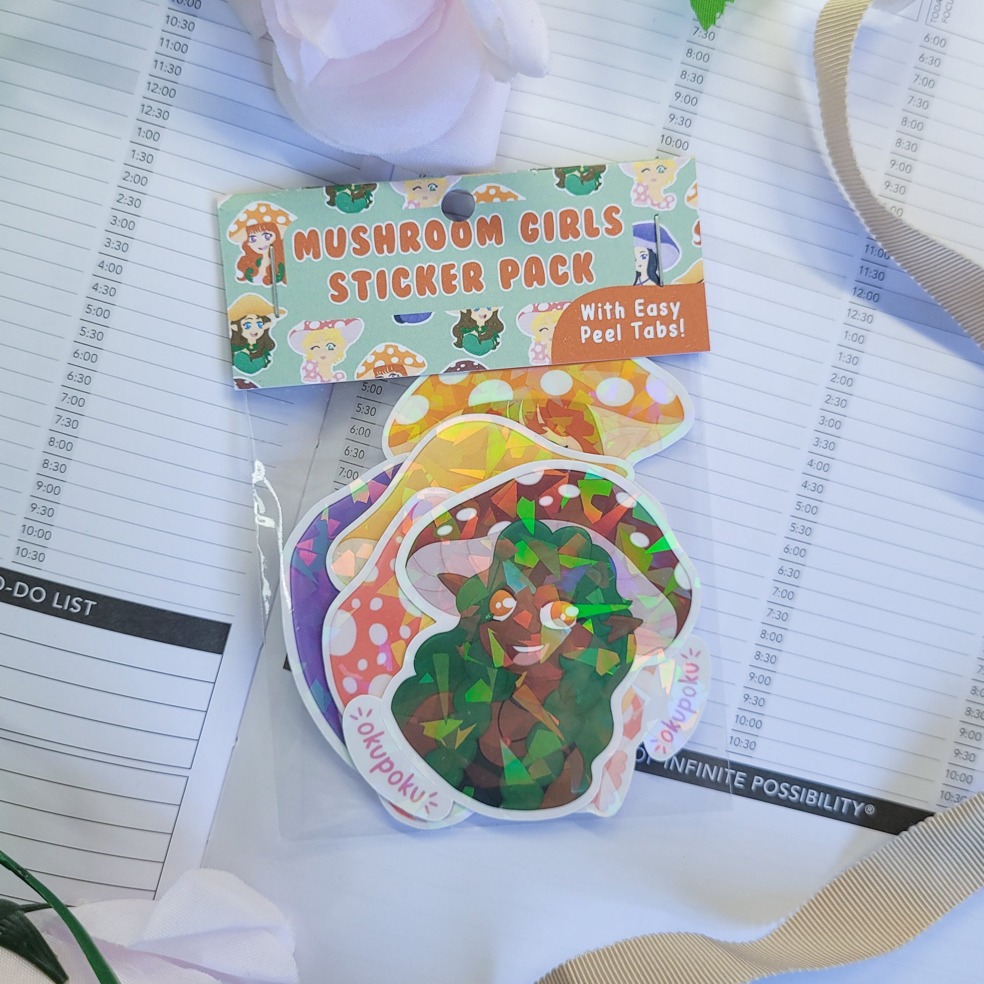 Mushroom Girls Sticker Pack on a planner with a pink flower in the background