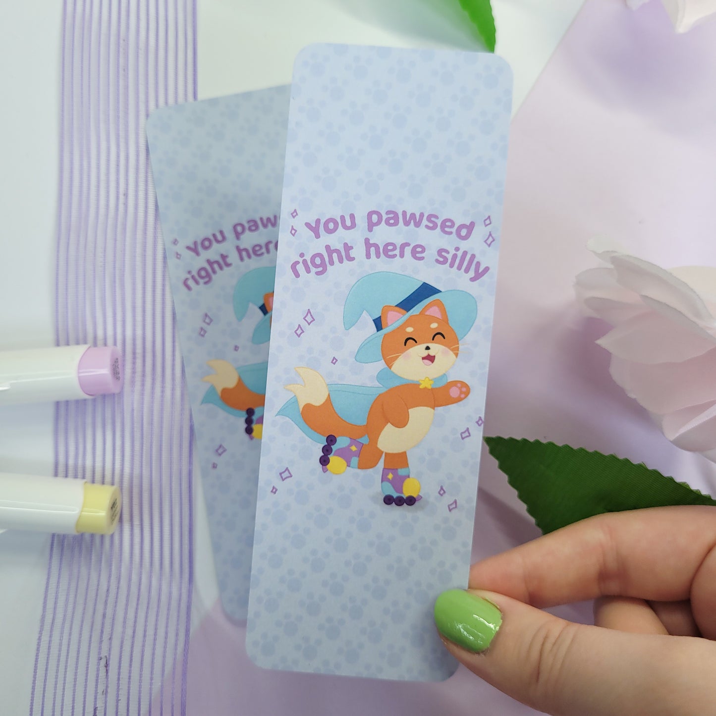 Katrina the kitty witch bookmark with her rollerskating with the text "you pawsed right here silly"