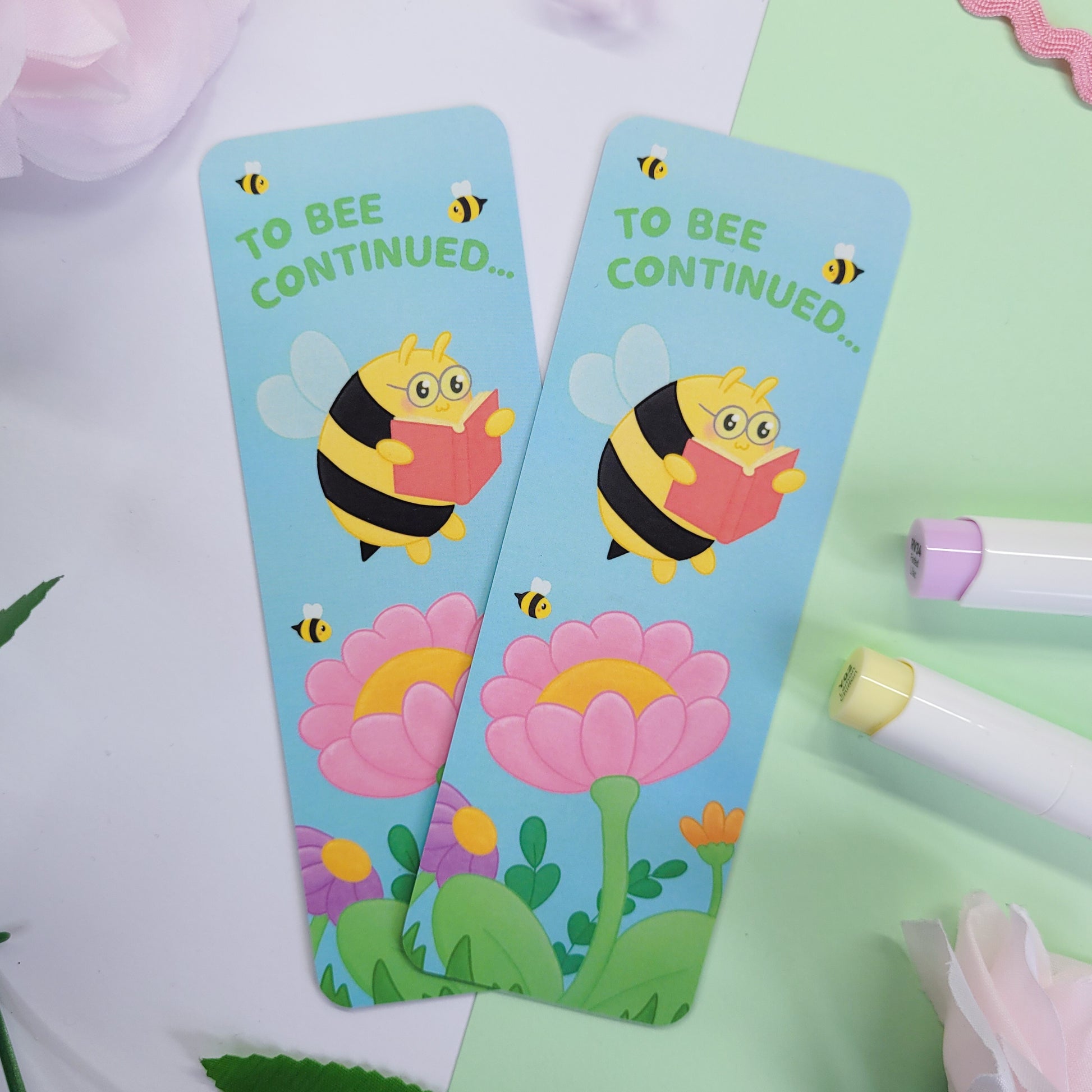 to bee continued bookmark featuring a bee reading among flowers