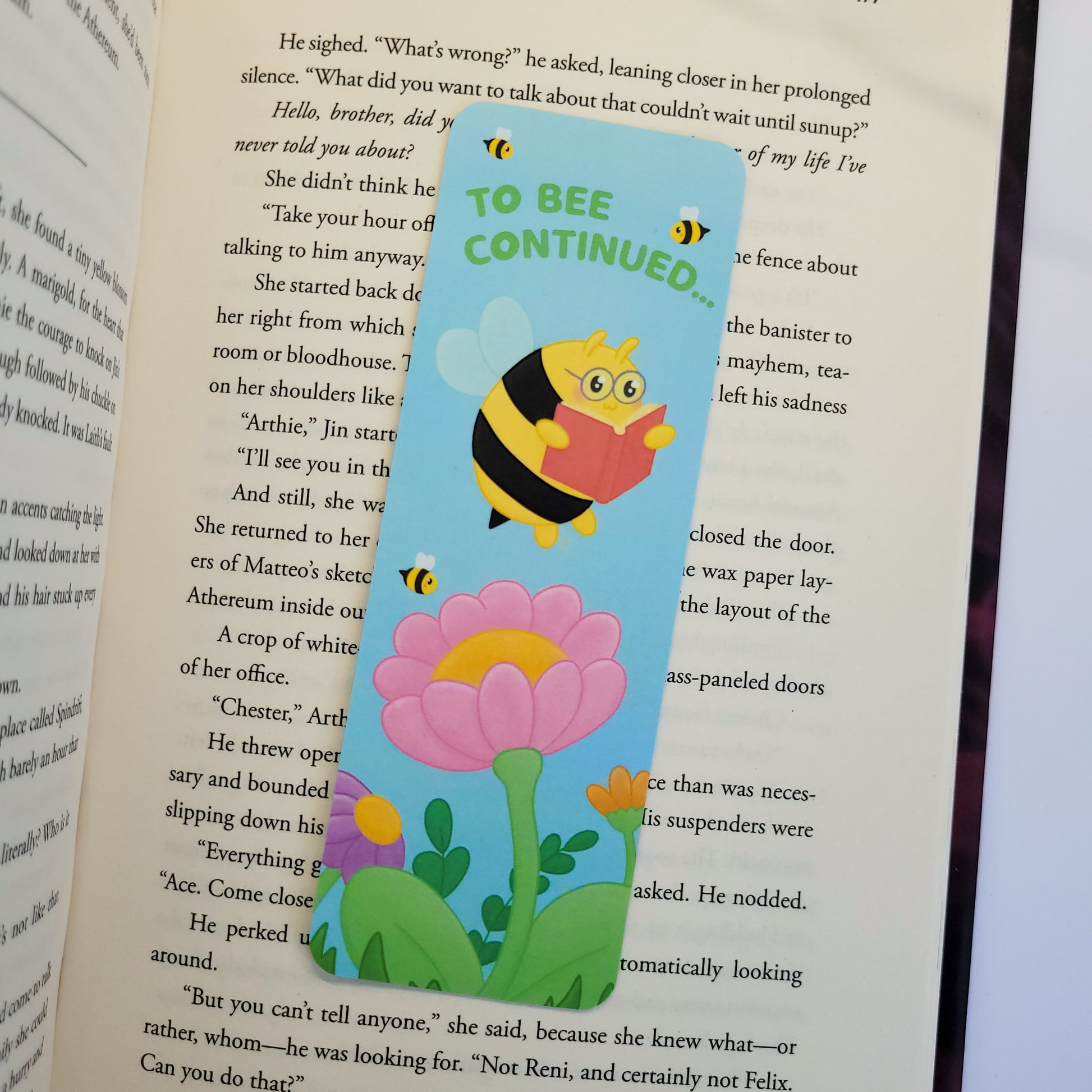to bee continued bookmark featuring a bee reading among flowers