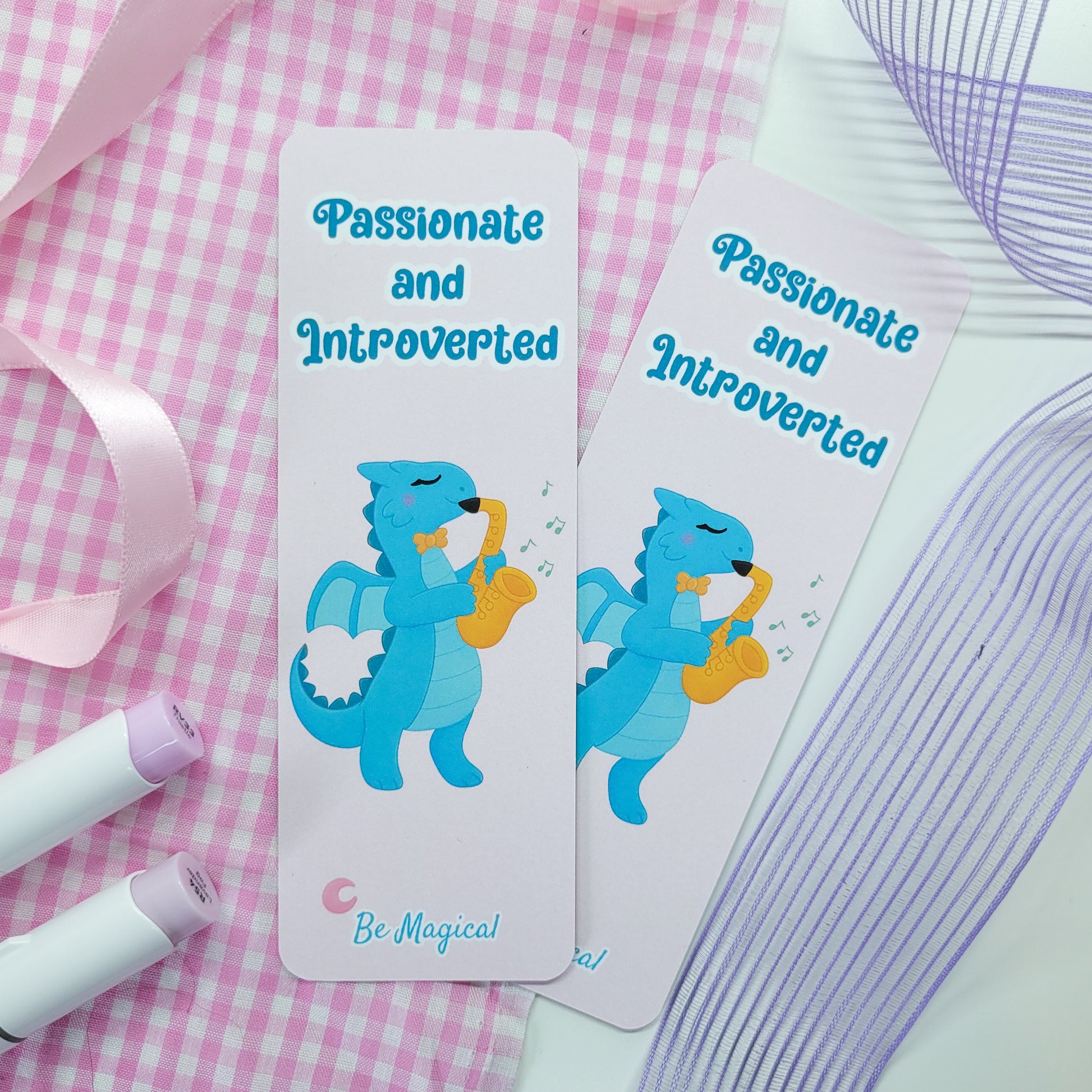 bookmark featuring "passionate and introverted" with a blue dragon playing the saxophone