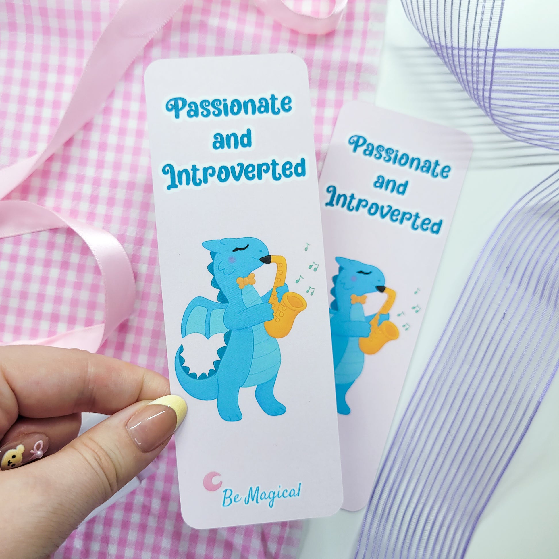 bookmark featuring "passionate and introverted" with a blue dragon playing the saxophone