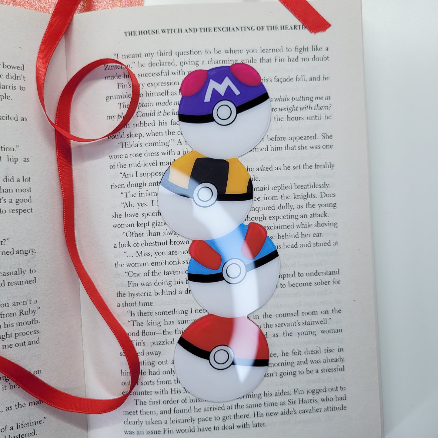Cute bookmark in the shape of 4 stacked pokeballs shown in use