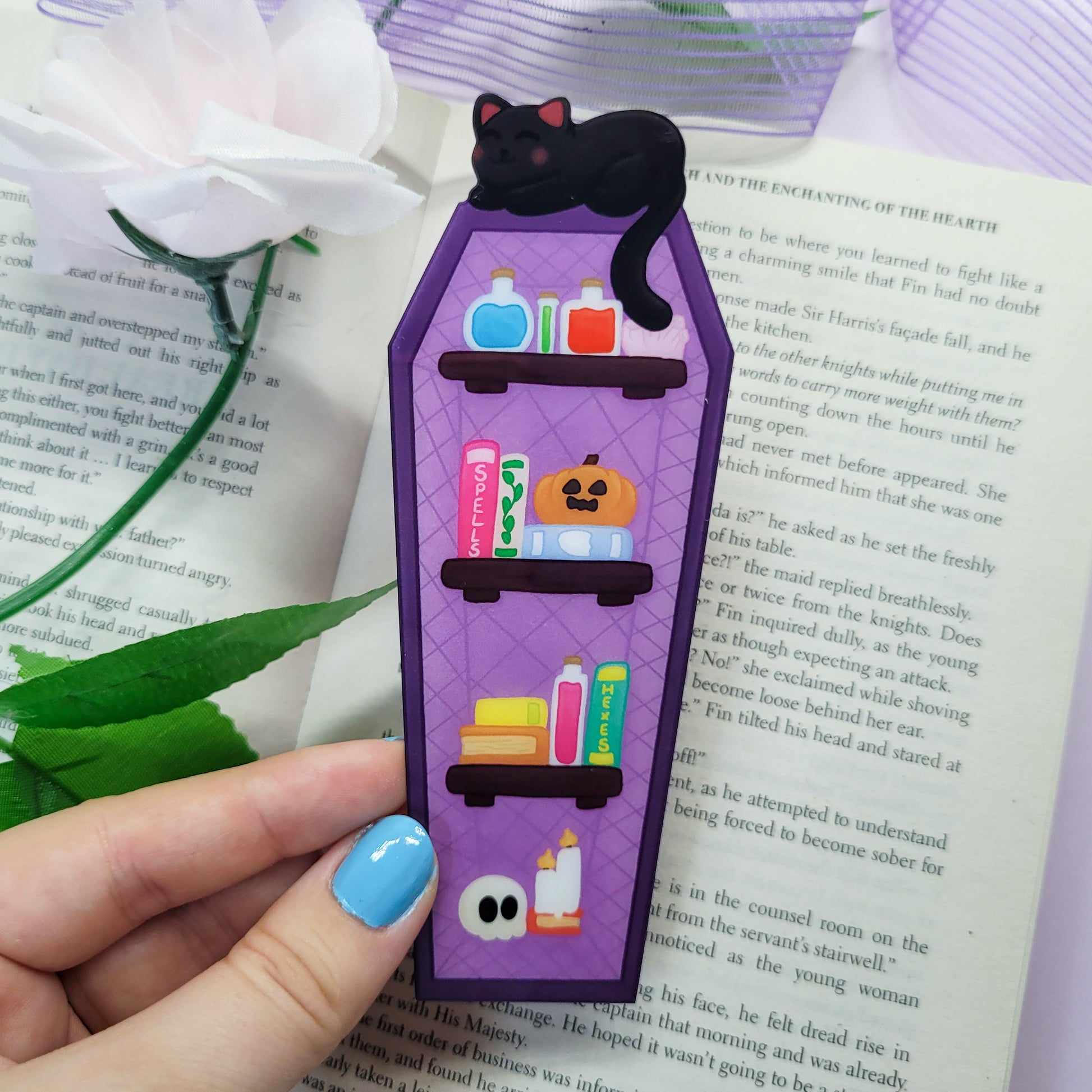 Gothic purple and black bookshelf with a black cat sat on top