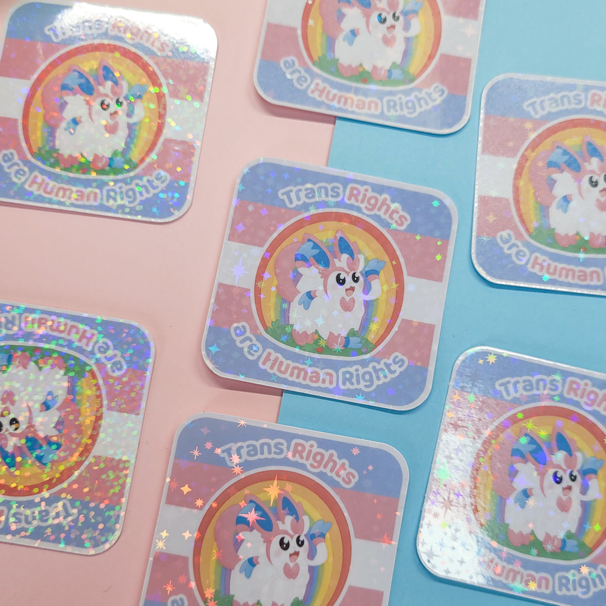 Holographic sticker of Sylveon with the text "trans rights are human rights"