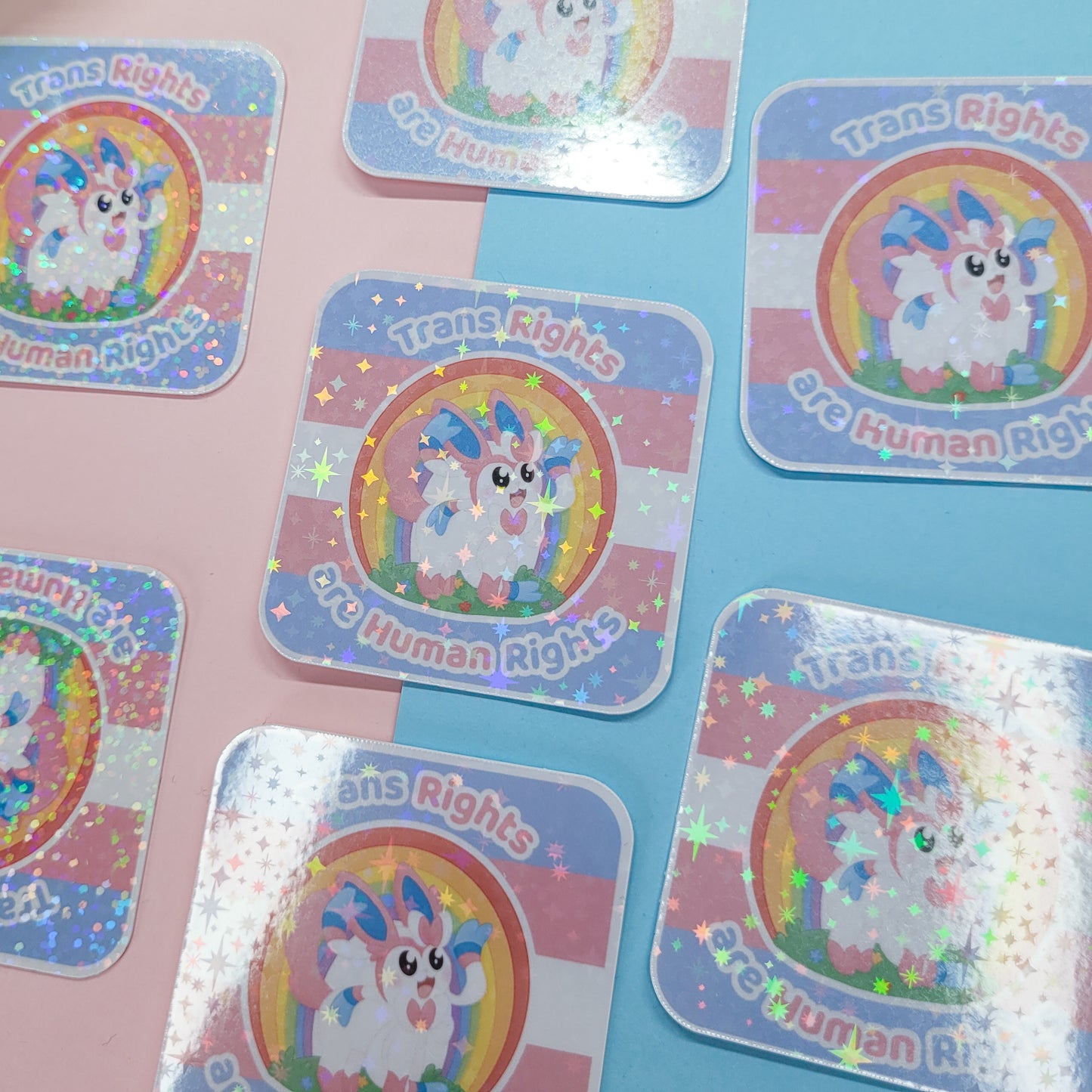 Holographic sticker of Sylveon with the text "trans rights are human rights"