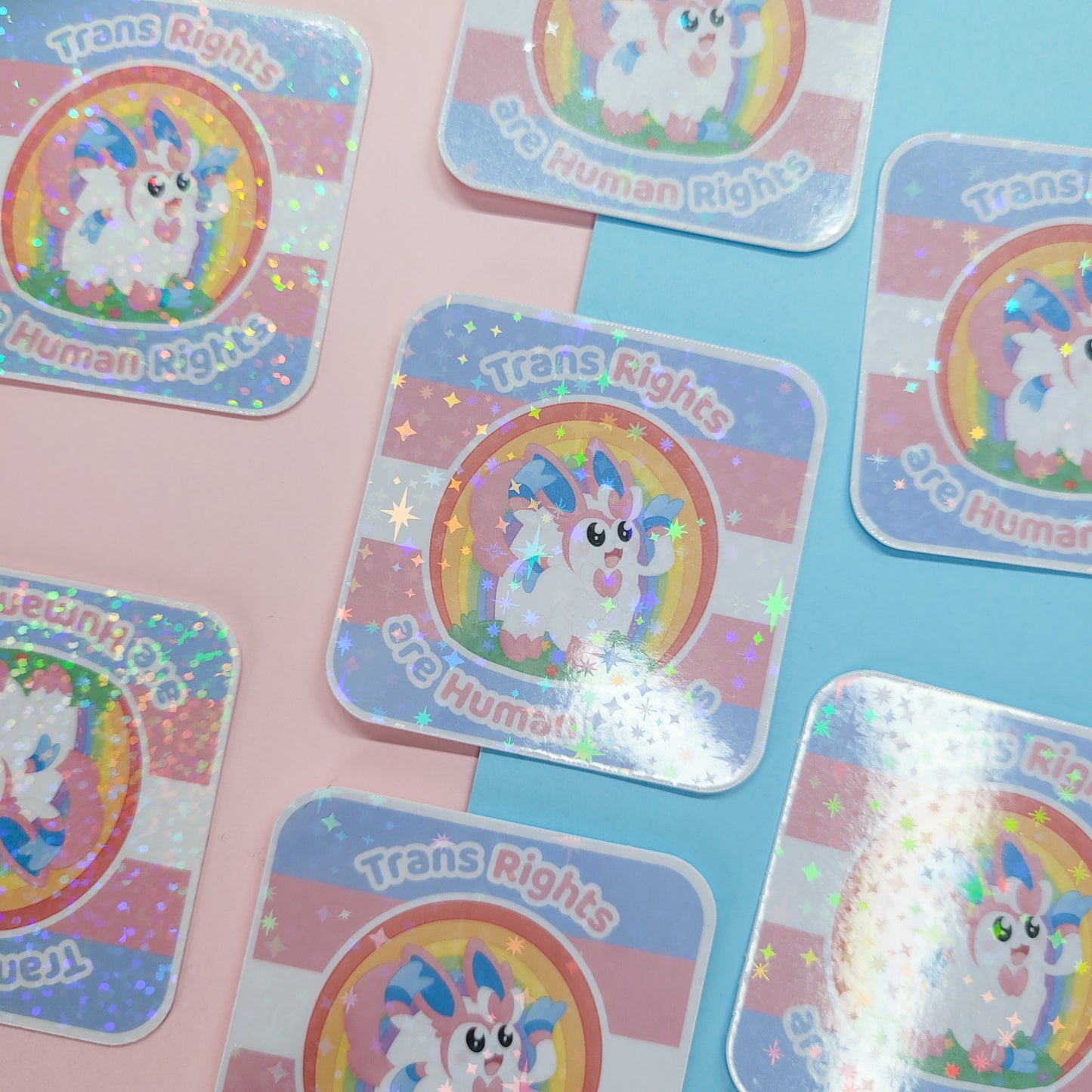 Holographic sticker of Sylveon with the text "trans rights are human rights"