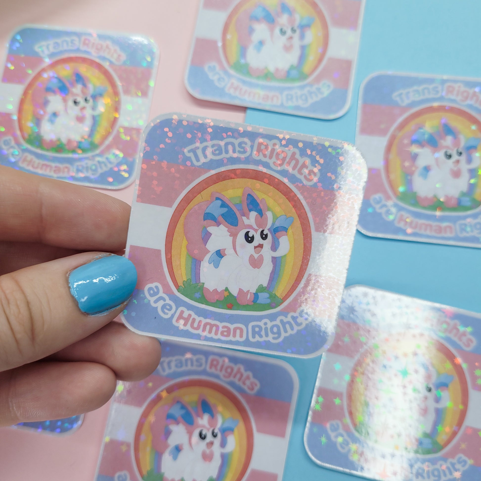 Holographic sticker of Sylveon with the text "trans rights are human rights"