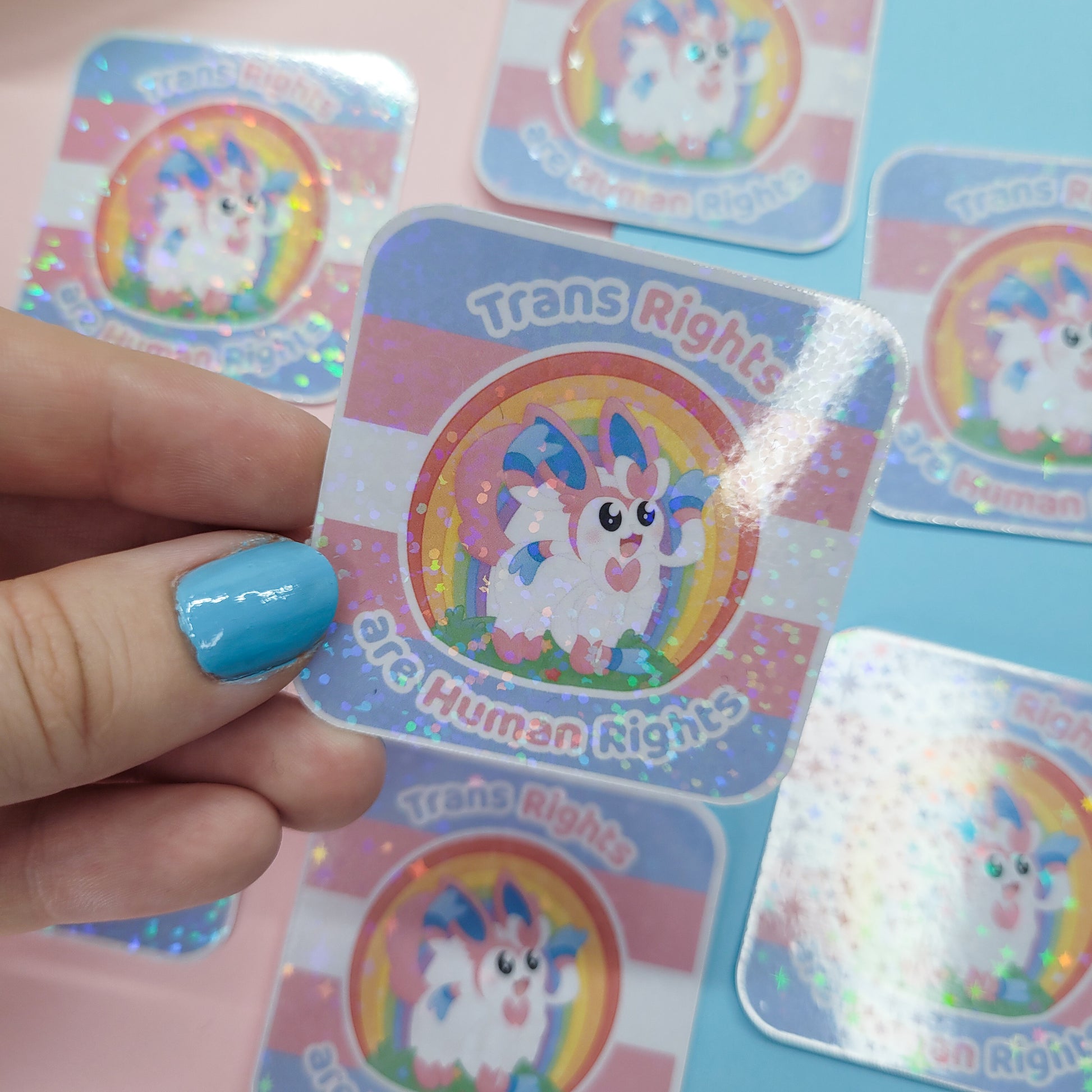 Holographic sticker of Sylveon with the text "trans rights are human rights"